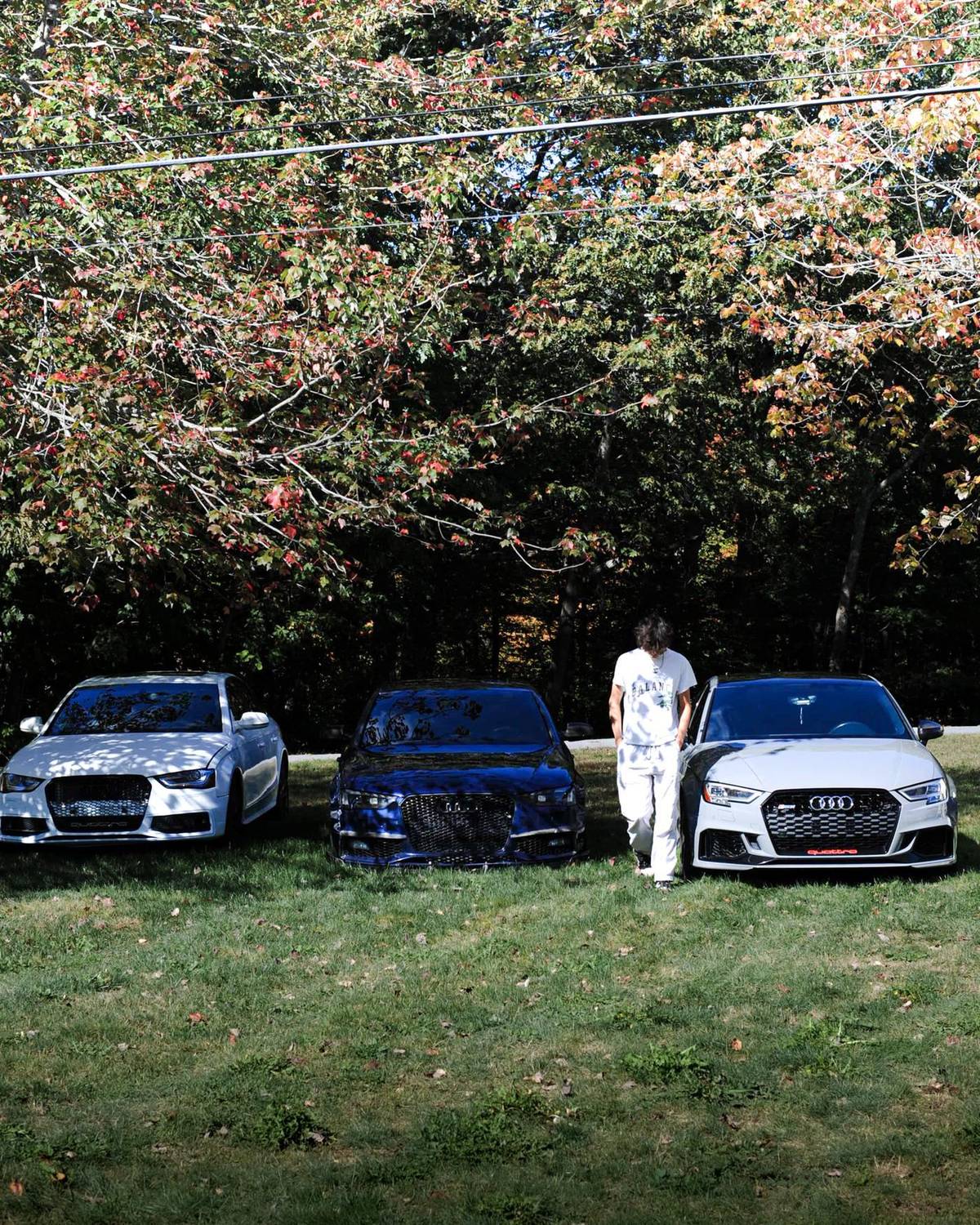 The founder of Redline Scents with his Audi S4, RS3, and S6 parked under fall trees